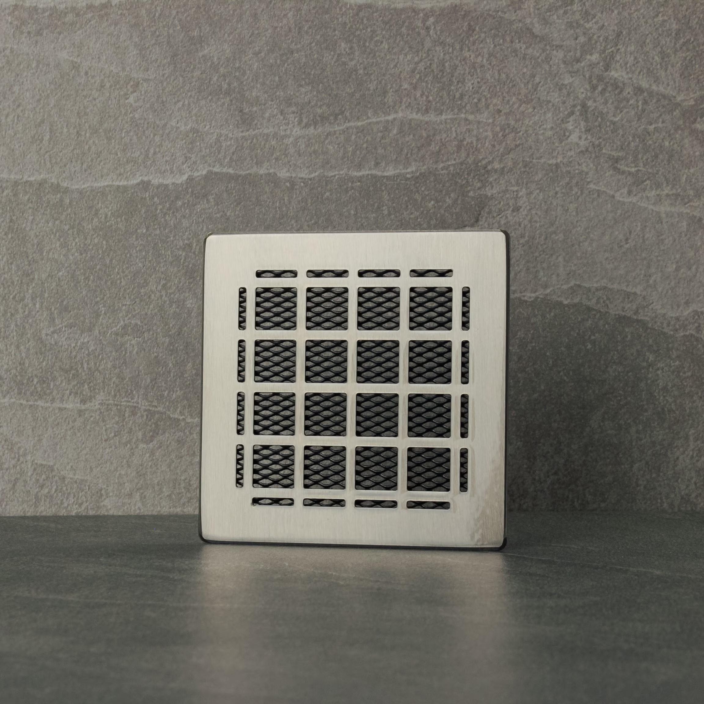 Decorative metal grille on a gray stone wall