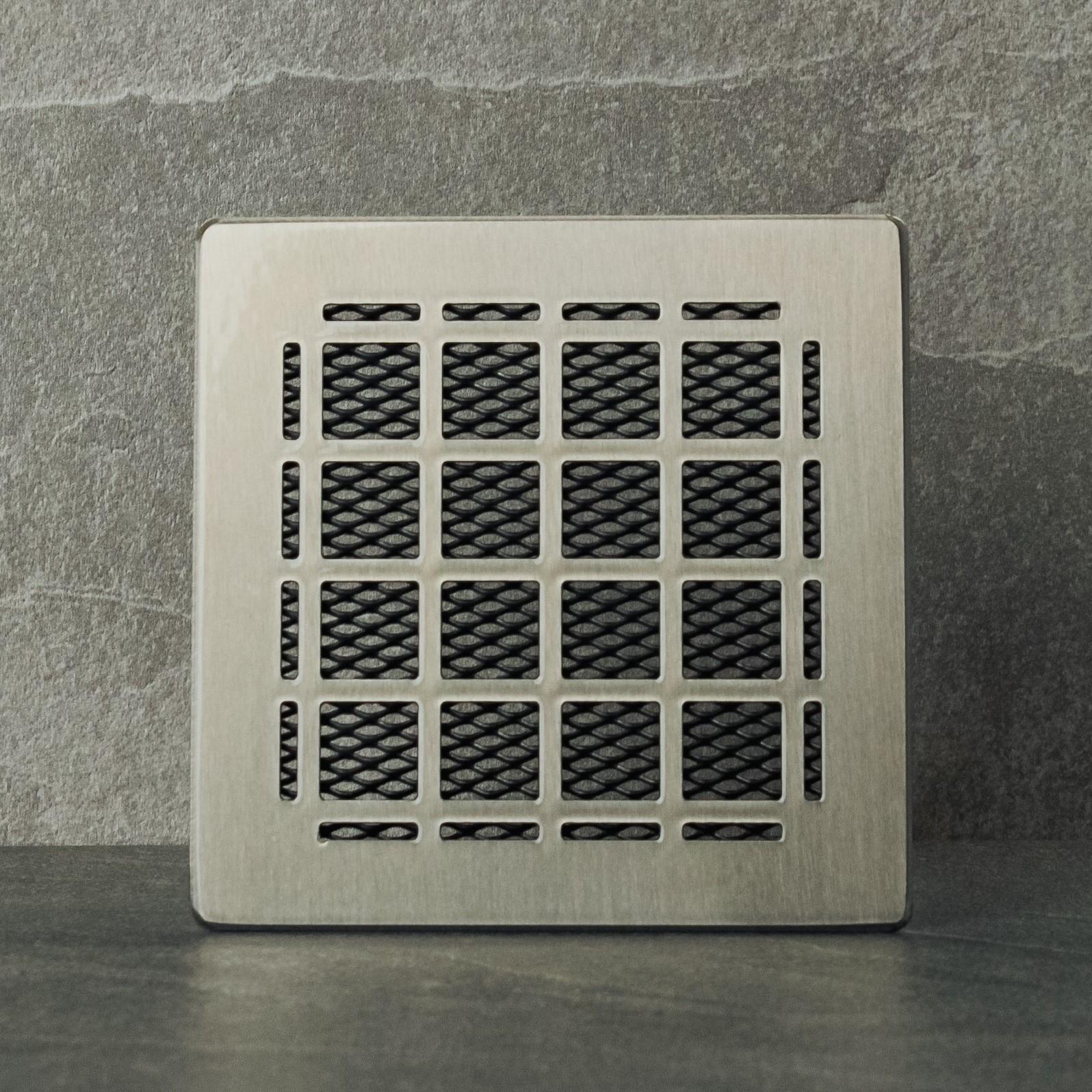 Metallic square vent on a gray stone background