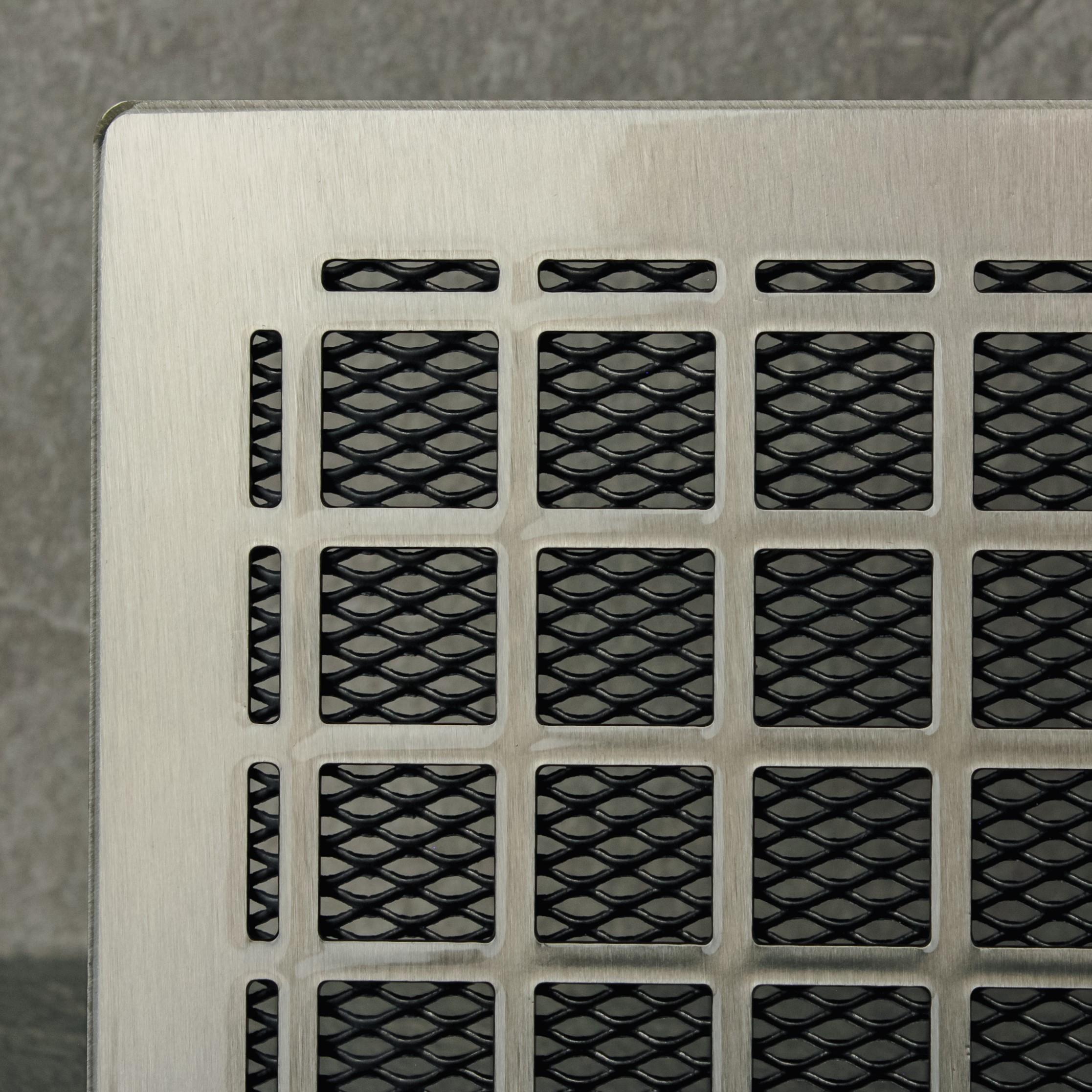Metallic vent cover with grid pattern on a textured background