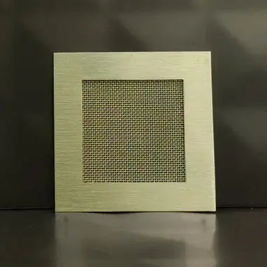 Square metallic grille on a dark background