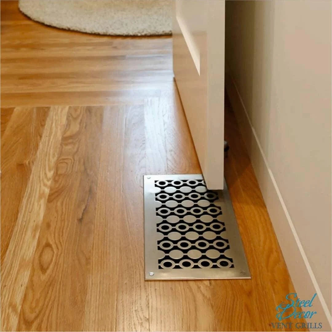 Decorative floor vent on a wooden floor with 'Steel Decor' branding.