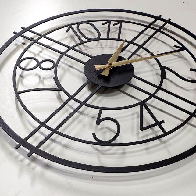Black wall clock with gold hands on a white background