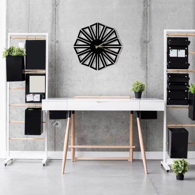 Modern office setup with a black geometric wall clock on a gray wall.