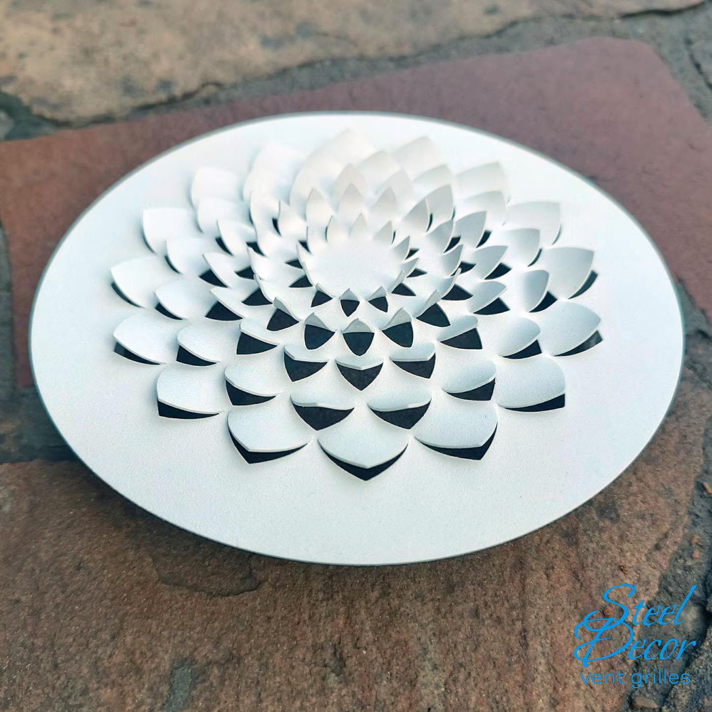 Decorative white metal vent grille on a stone surface with 'Steel Decor' branding.