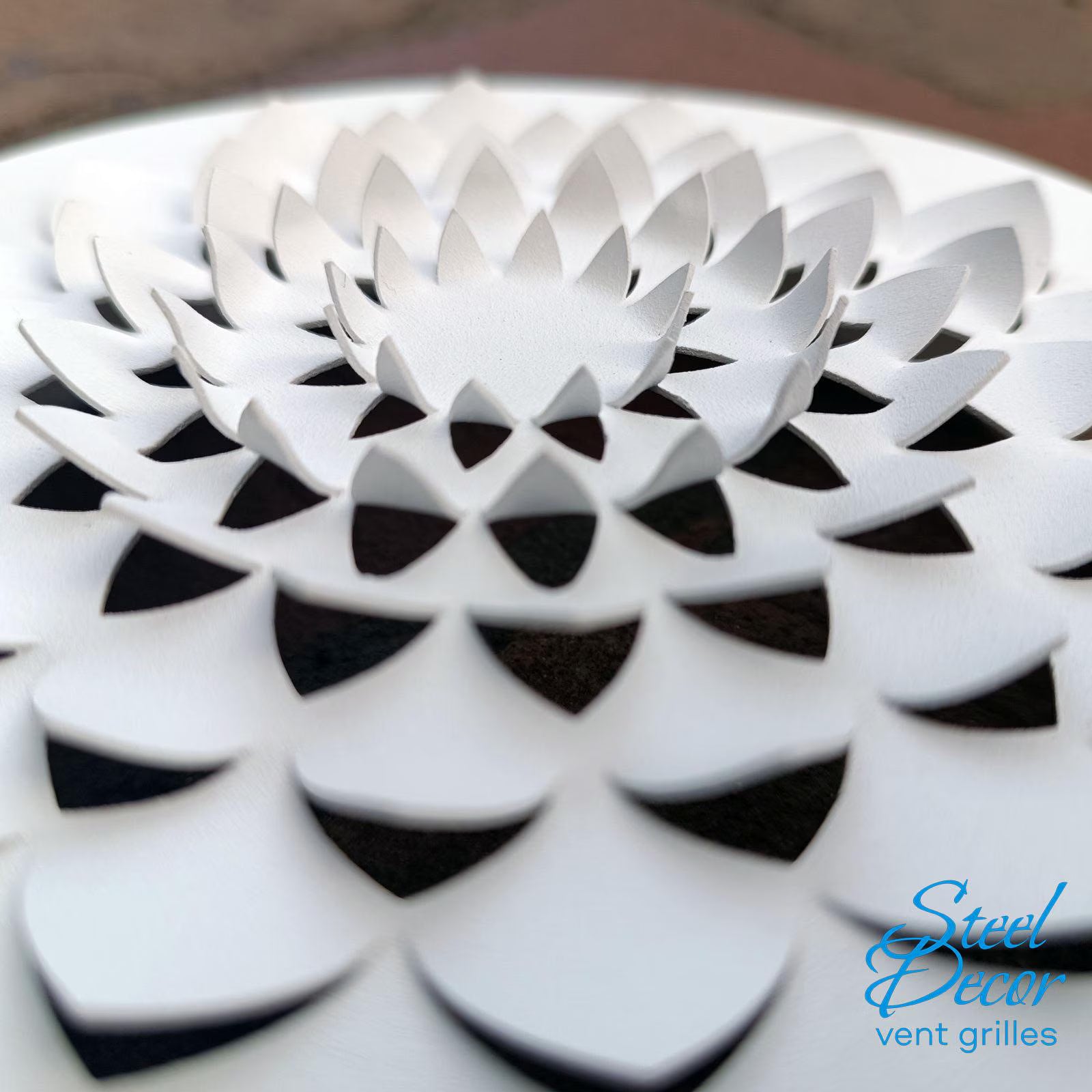 Close-up of a white decorative vent grille with 'Steel Decor' branding.